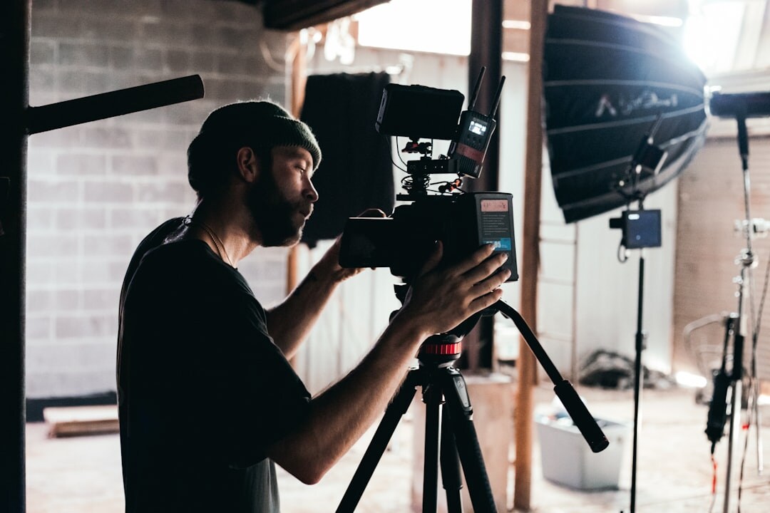 Technician setting up studio camera equipment on tripod
